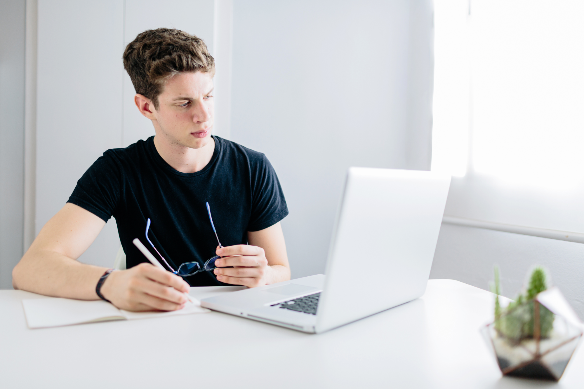 man writing a note on a notebook and using laptop scopio 127d3f14 1604 4233 bf88 08e1d912098f